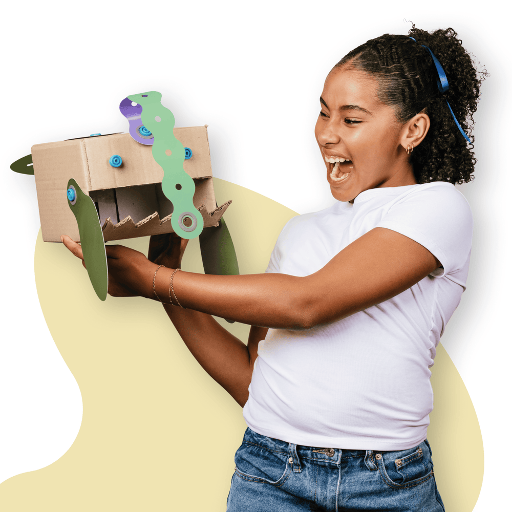 Makedo Deco-Props Blobbies cardboard creation with girl who looks excited about what she has made.